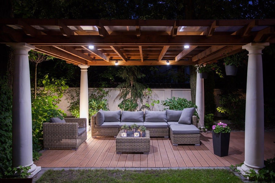 A well-lit outdoor gazebo with a table and patio chairs. 
