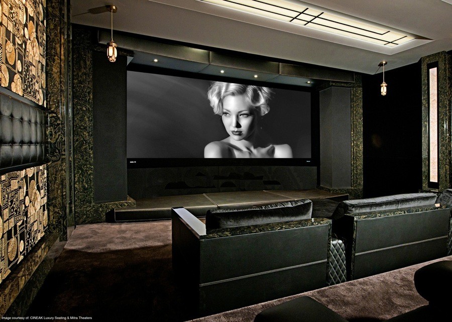 A fancy home theater with a black and white movie displayed on the screen.